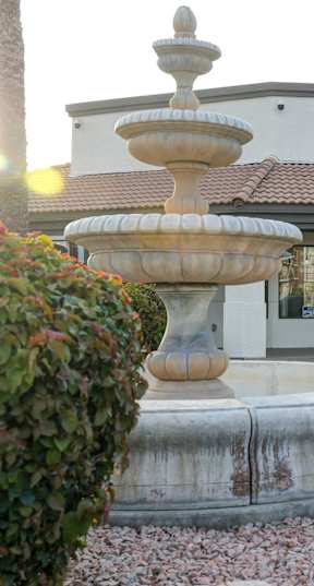 A sign that says San Clemente sits in front of a wall of flowers.