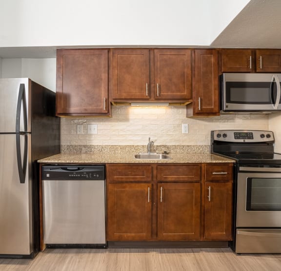 a kitchen with wooden cabinets and stainless steel appliances
