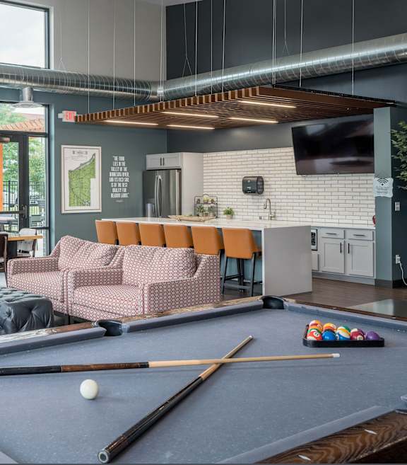 A pool table with a cue stick and balls on it.