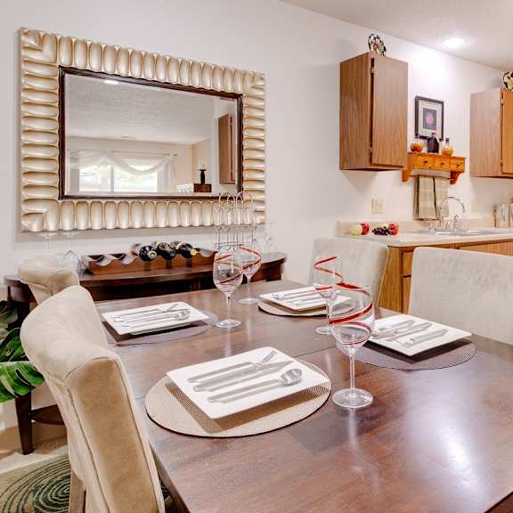 Dining room in a Regency Woods model unit, featuring a dining table with the kitchen visible in the background.
