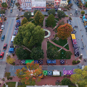an aerial view of a city street with cars and trees