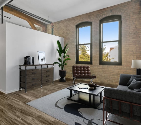 a living area with a couch coffee table and a kitchen in the background
