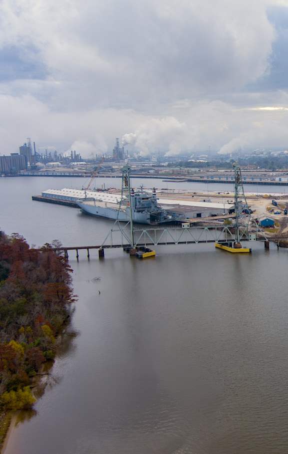 A large body of water with a dock and a crane in the background.
