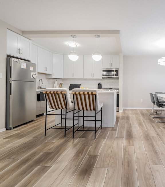 A kitchen with a dining table and chairs.