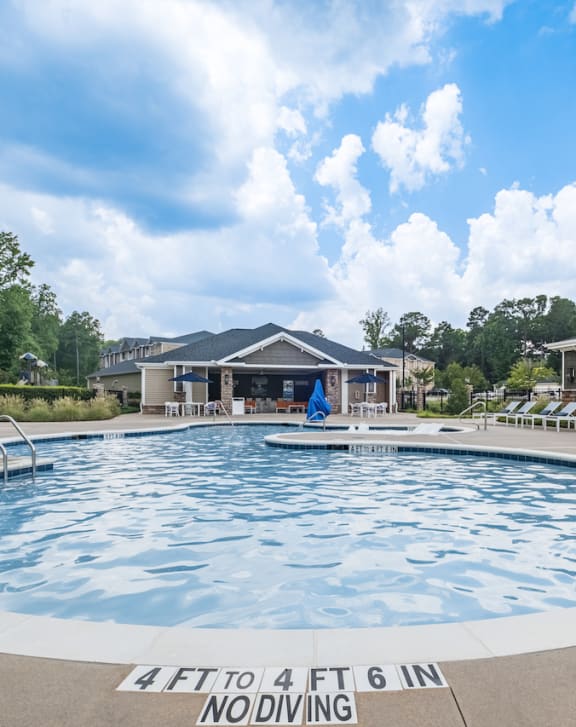 a large pool with a house in the background