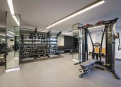 Thumbnail 11 of 24 - Gym with weights and a weight machine at NoMa Apartments, Walnut Creek, CA