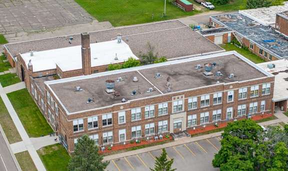 A large brick building with a parking lot in front.