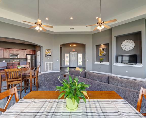 A dining room with a table set for two and a potted plant in the middle.