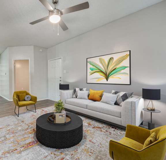 a living room with a ceiling fan and a dining room table with chairs