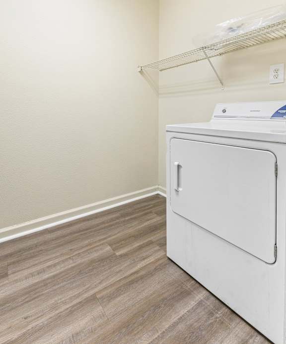 A white washing machine in a small laundry room. at Northampton Village Apartments, Indianapolis, Indiana