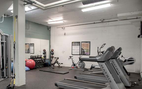 A gym with treadmills, exercise balls, and other equipment.