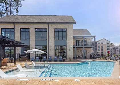 A large building with a pool in front of it.