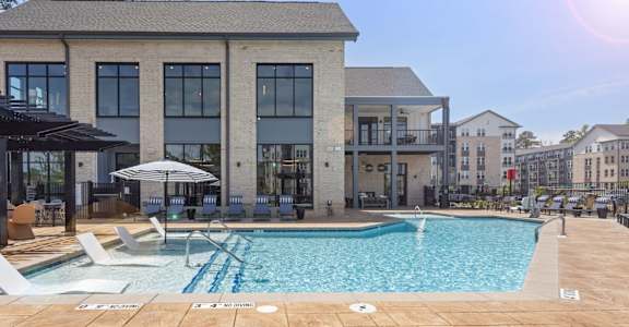 A large building with a pool in front of it.