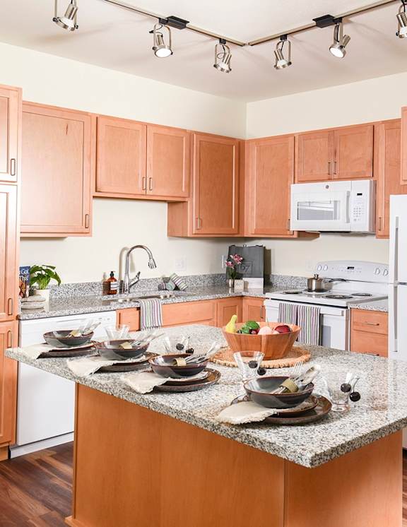 A kitchen with wooden cabinets and a granite countertop.