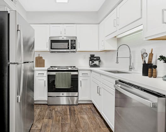 A modern kitchen with stainless steel appliances and white cabinets.