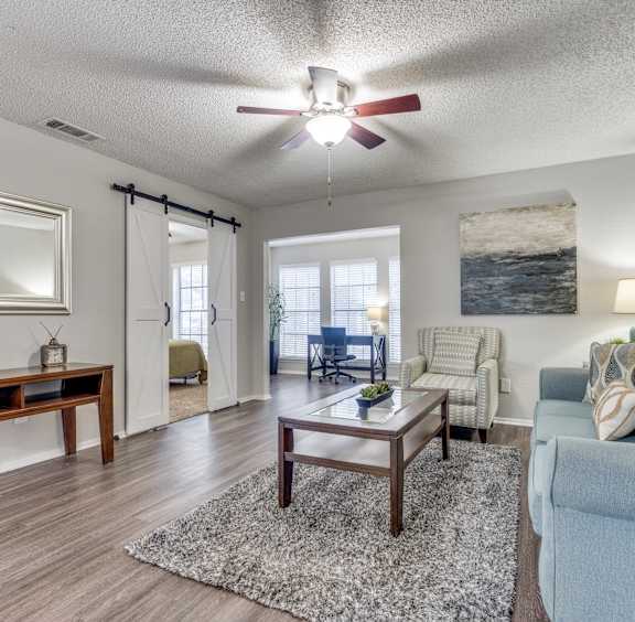 A bedroom with a bed, nightstand, and a ceiling fan.