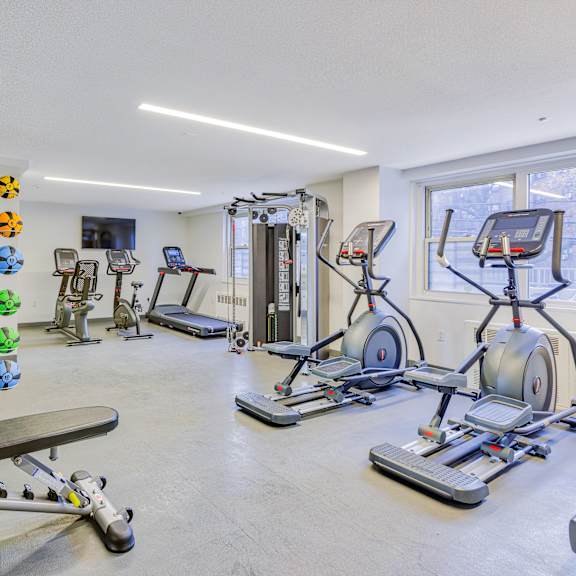 a workout room with cardio equipment and weights in a home gym