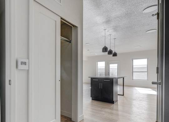 A white Samsung washing machine is in a laundry room with a doorway leading to another room.