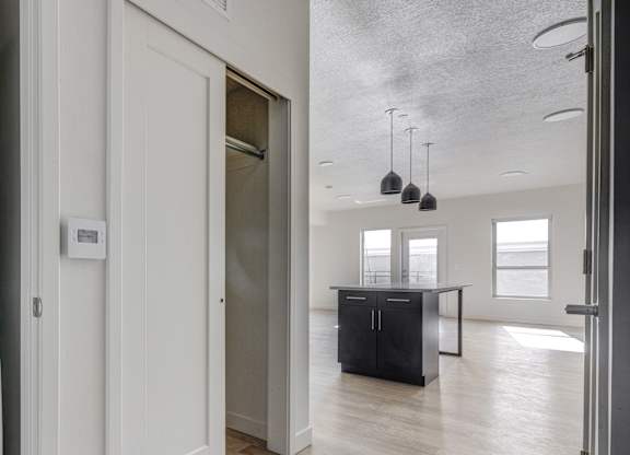 A white Samsung washing machine is in a laundry room with a doorway leading to another room.