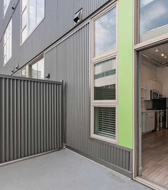 A modern house with a grey exterior and a glass door leading to the interior. at RiDE at RiNo Apartments, Colorado