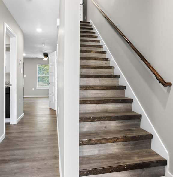 A staircase with wooden steps and a blue door on the left.