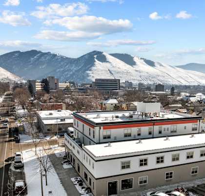 A snowy mountain range is in the background of a city street.