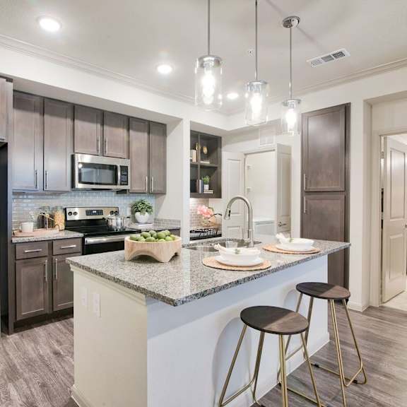 A kitchen with a large island and stools.