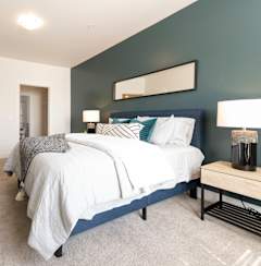 a blue and white bedroom with a bed and a dresser