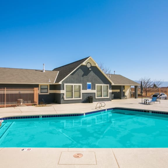 a swimming pool with a house in the background