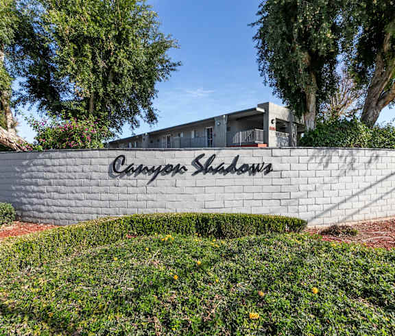 A wall with the words and greenery at Canyon Shadows Apartments, Riverside, CA 92503