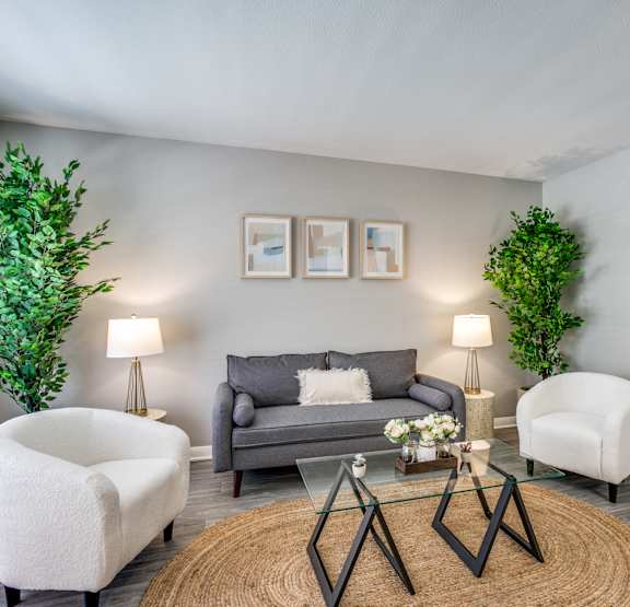 a living room with a ceiling fan and a dining room table with chairs