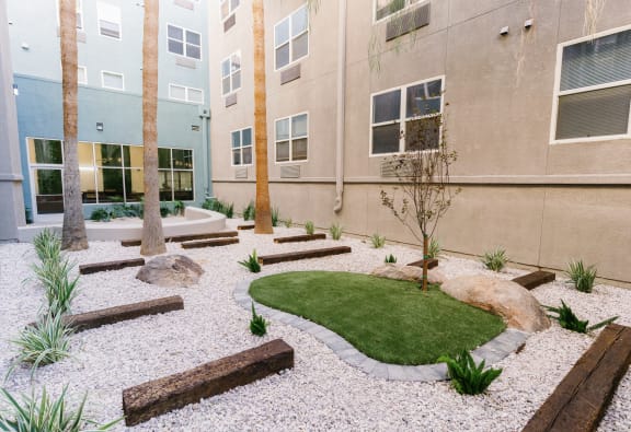 a courtyard with grass and rocks in front of a building at The Vine on 8th, Nevada
