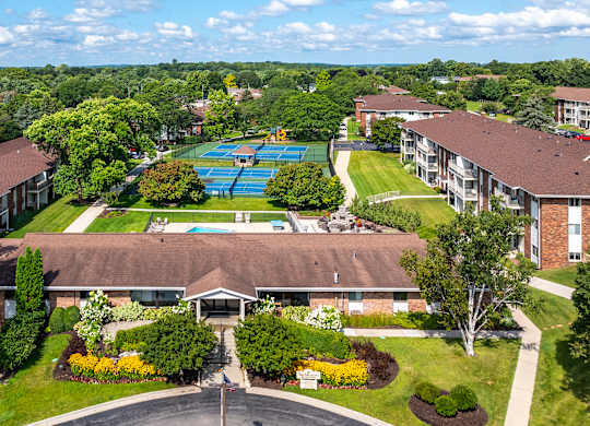 A large building with a pool in the middle of a green lawn.