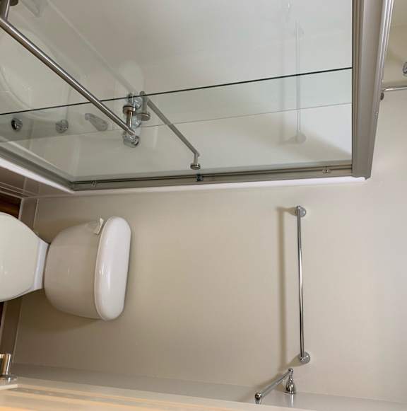 a bathroom with a glass shower and a toilet and a sink