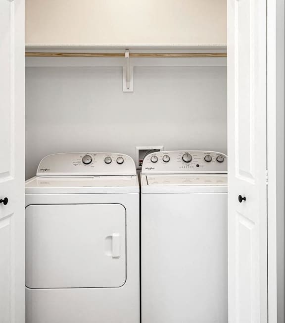 A white washing machine and dryer in a small laundry room.