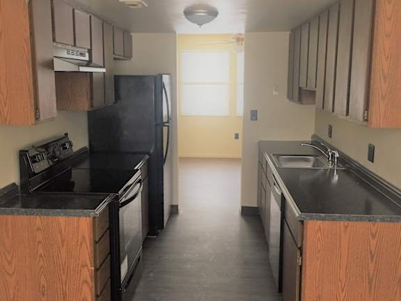 A kitchen with black appliances and wooden cabinets at Haven East, Maine, 04011