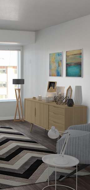 A living room with a white couch, a grey armchair, and a wooden cabinet.