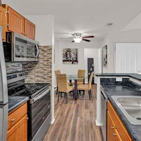 A kitchen with a white refrigerator and wooden cabinets.