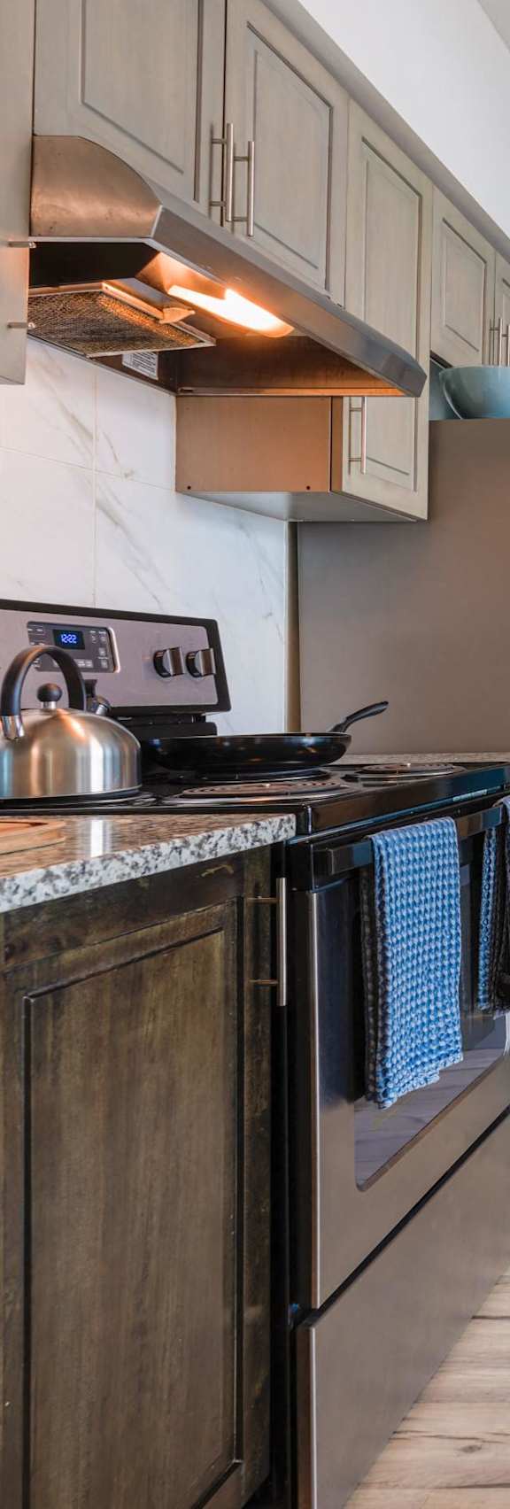 a kitchen and dining room with stainless steel appliances and a door to a hallway