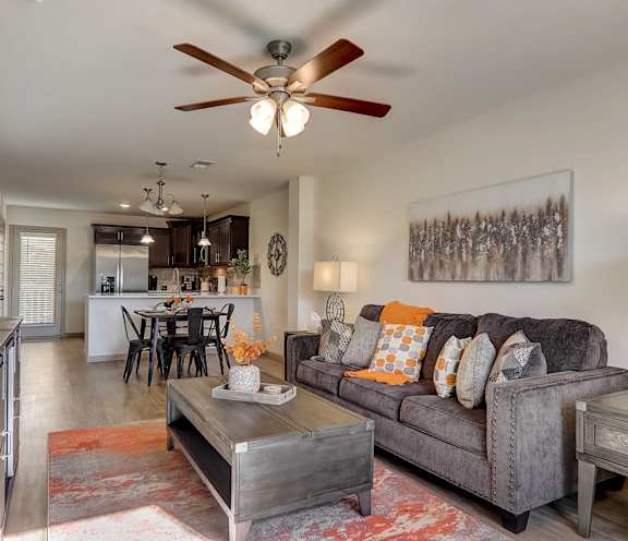 a living room with a couch and a ceiling fan