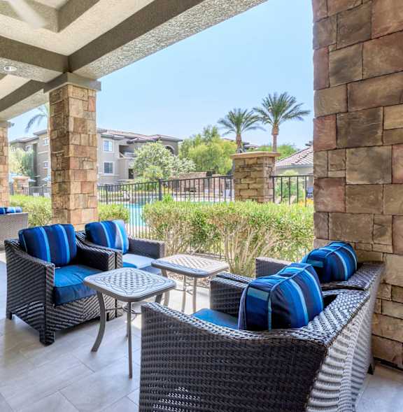 A patio with blue cushions and a table.
