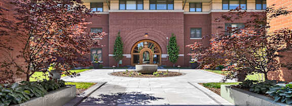A courtyard surrounded by buildings with a fountain in the middle.