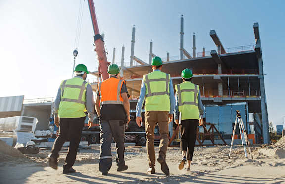 a construction site with stacks of wood and a worker working on it