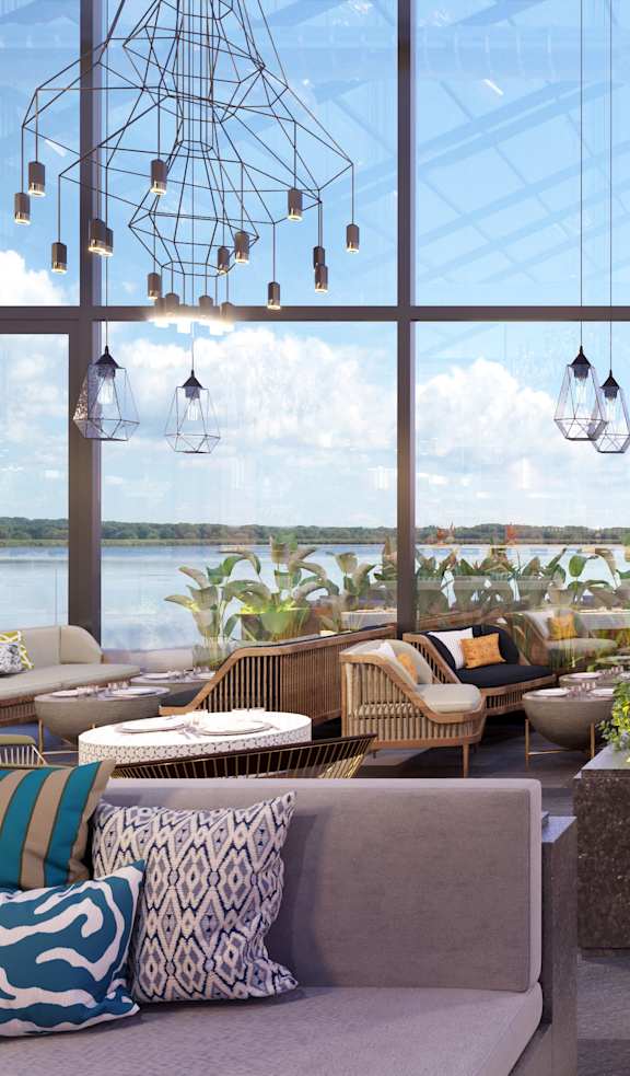 A modern outdoor seating area with a view of the water and sky.
