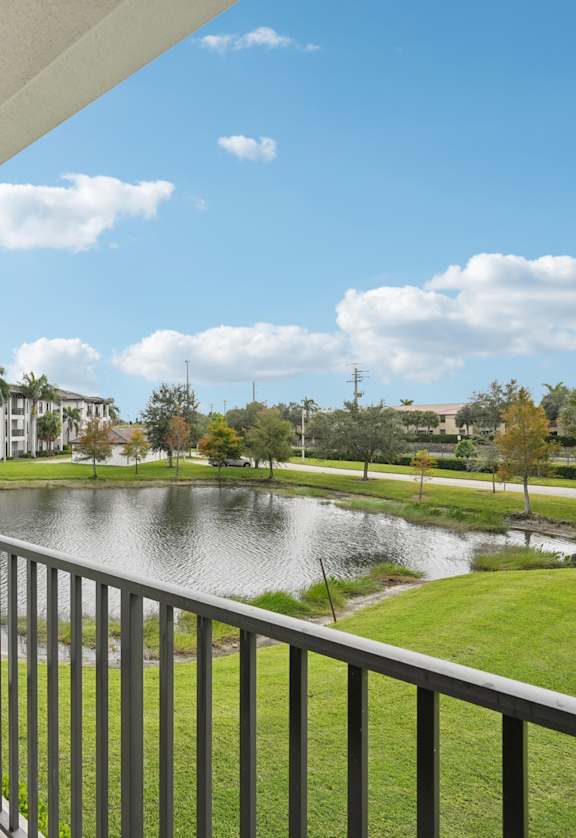 A balcony overlooks a pond and a park.
