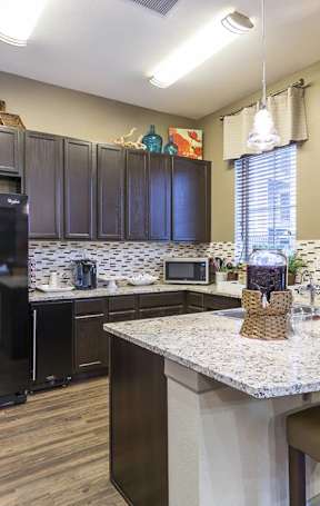 A kitchen with a black fridge and a white counter top.