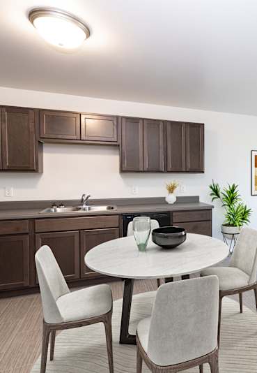 A modern kitchen with a dining table and chairs.