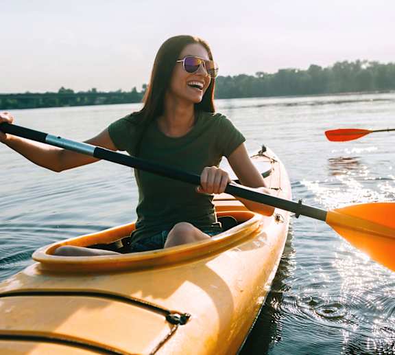 Two people kayaking on a calm body of water.