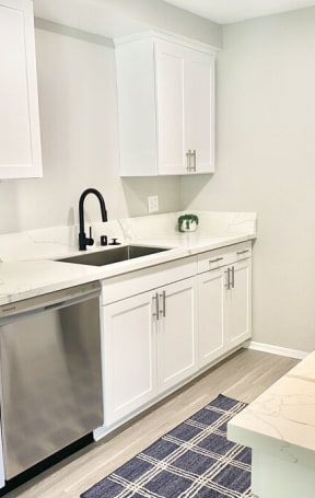 a kitchen with white cabinets and a stainless steel refrigerator at BLVD Apartments LLC, Tarzana, 91356