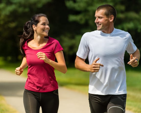 a man and a woman running in a park